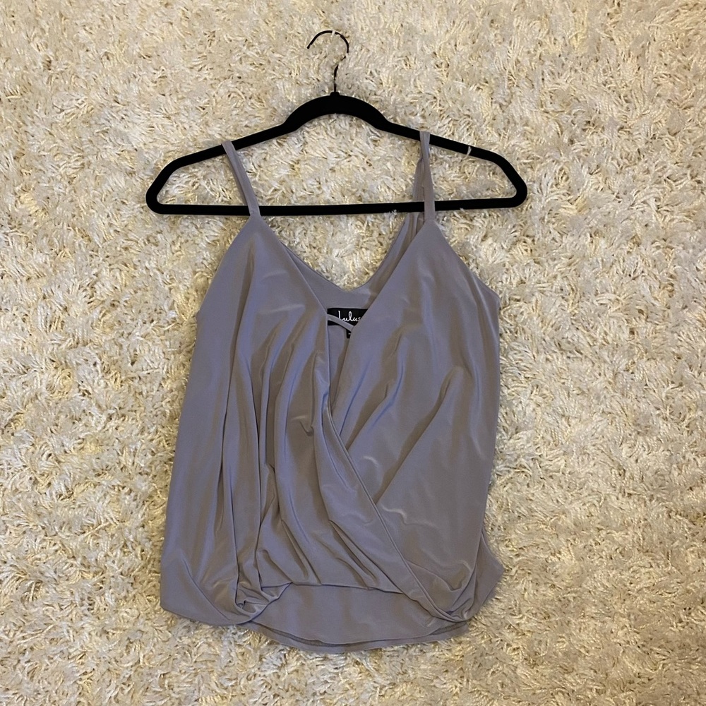 Slight high/low tank top with cut out at chest. Polyester and spandex material